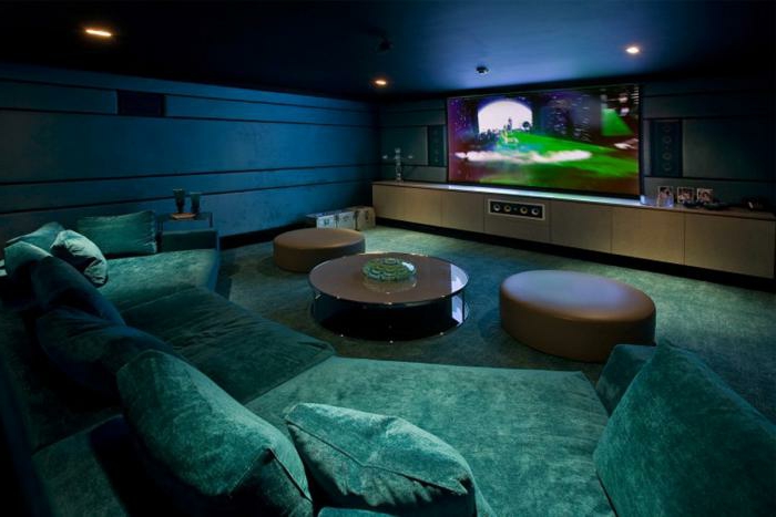 elegantes-innovatives-Wohnzimmer-Interieur-großer-Fernseher-grüne-xxl-couch-Samt-halbrundes-Sofa