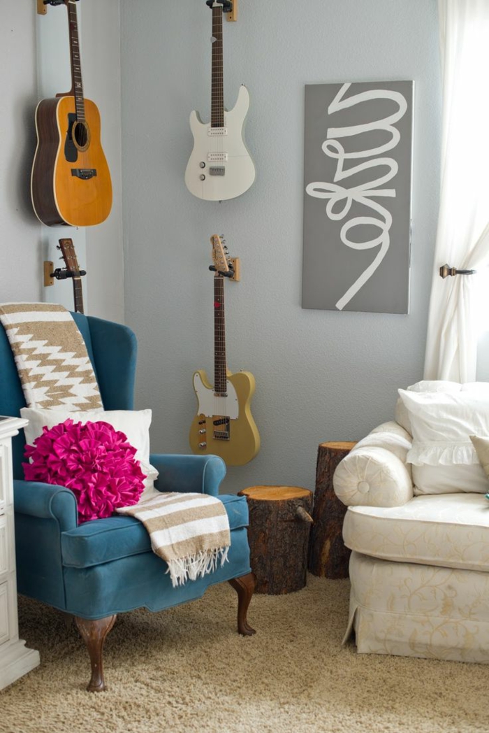 gemütliches-Wohnzimmer-Sessel-mit-feinem-Design-artistisches-Wandbild-elektronische-Akustik-Gitarre-an-der-Wand