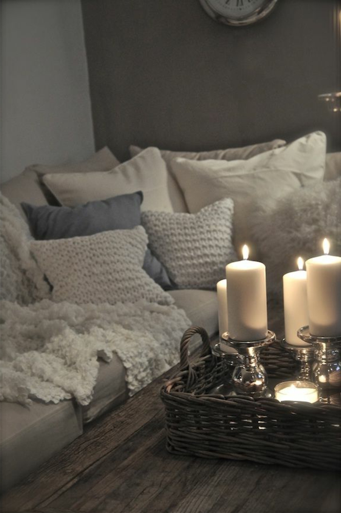 gemütliches-Wohnzimmer-Sofa-viele-Kissen-gestrickte-Modelle-weiche-Nuancen-Kerzen-romantische-Atmosphäre