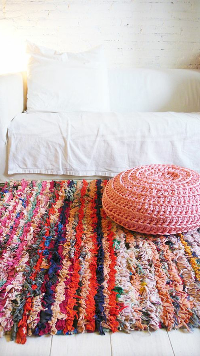 gemütliches-Zimmer-Bett-weiße-Bettwäschen-Crochet-Hocker-handgemachter-Teppich-bunte-Streifen
