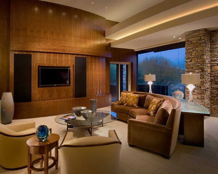 gemütliches-räumliches-Wohnzimmer-Möbel-Pastellfarben-Sessel-braunes-Sofa-halbrunde-Form