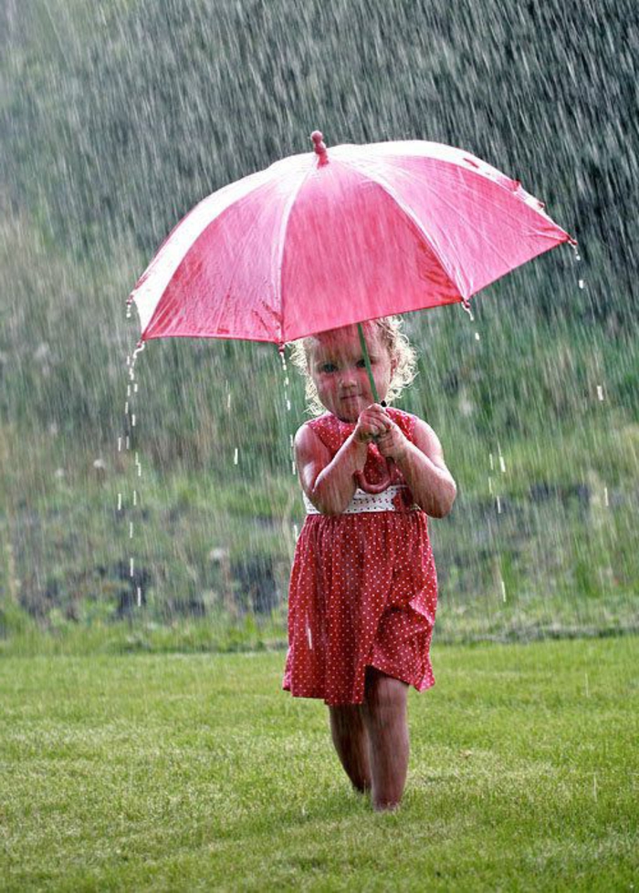 kleines-Baby-läuft-mit-rosa-Regenschirm