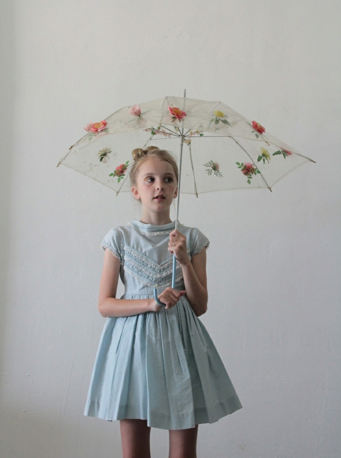 kleines-Mädchen-blaues-Kleid-koketter-Kinderschirm-Blumen-Dekoration