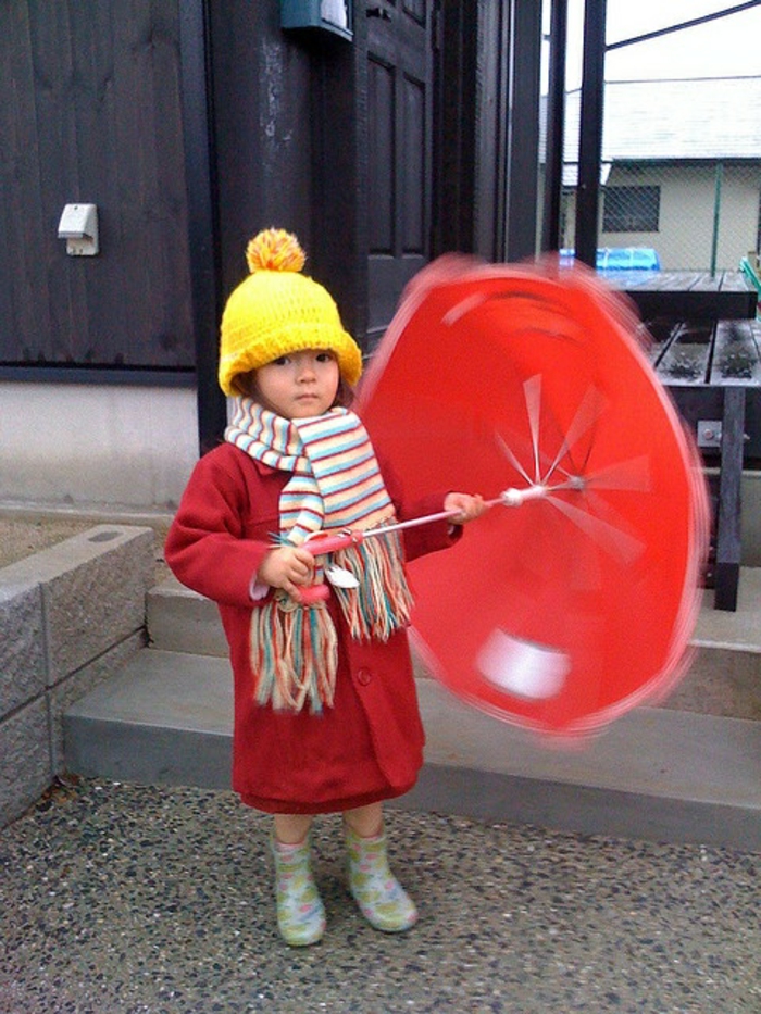 kleines-süßes-Mädchen-roter-Mantel-bunter-Schal-roter-kinderregenschirm