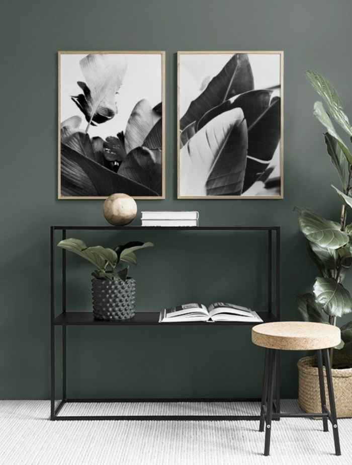 Dunkelgrüne mit zwei aufgehängte Bilder mit Naturmotiven, moderner schwarzer Kommode, große Wandbilder 