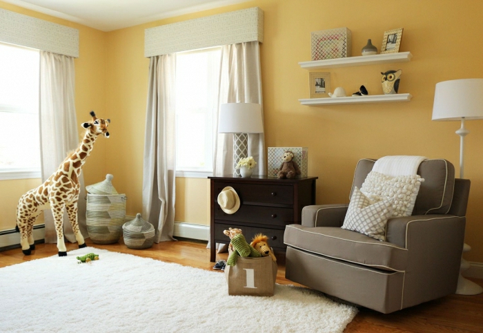 minimalistisches-Kinderzimmer-gelbe-Wände-viele-Plüschtiere-grauer-Sessel-flaumiger-Teppich-weiß
