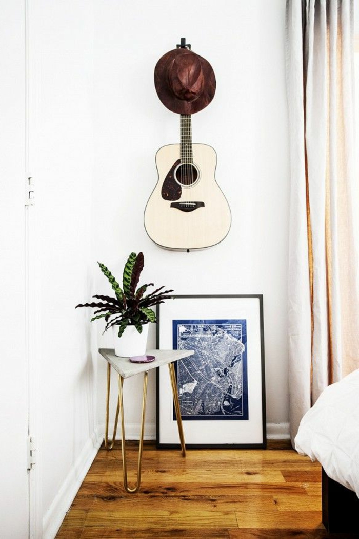 minimalistisches-Schlafzimmer-originelle-Wandgestaltung-brauner-Hut-weiße-akustische-Gitarre