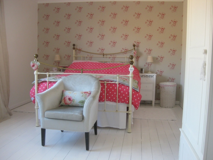 romantisches-Schlafzimmer-Interieur-vintage-Bett-schöne-rote-polka-dot-Bettwäsche-eleganter-Sessel-vintage-Tapete