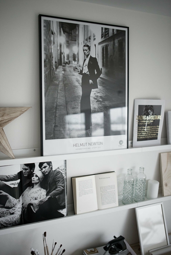 großes schwarz weißes Foto angelehnt an die Wand, aufgeschlagenes Buch, zwei Flaschen aus Glas, Schöne Wandbilder