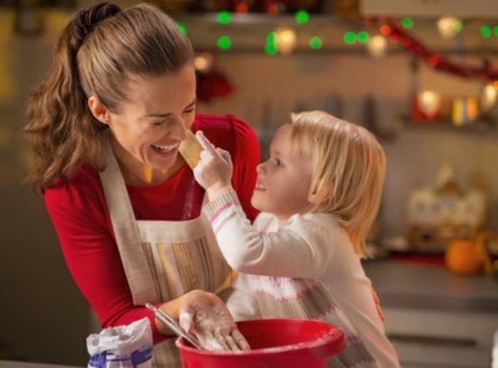 Baby trying to smear mothers nose with flour while making christmas cookies