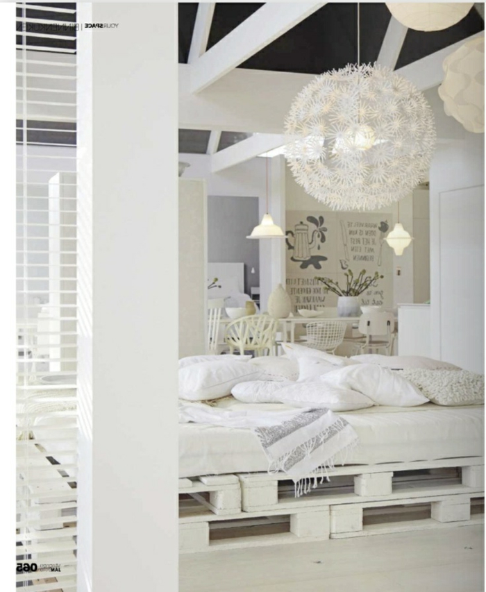 weißes-Schlafzimmer-Interieur-stilvoll-exquisit-bett-aus-europaletten-effektvoller-Kronleuchter