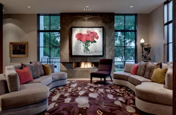 zwei-halbrunde-Sofas-Samt-extravaganter-Teppich-Sessel-weinrote-Farbe-schönes-Wandbild-Kamin