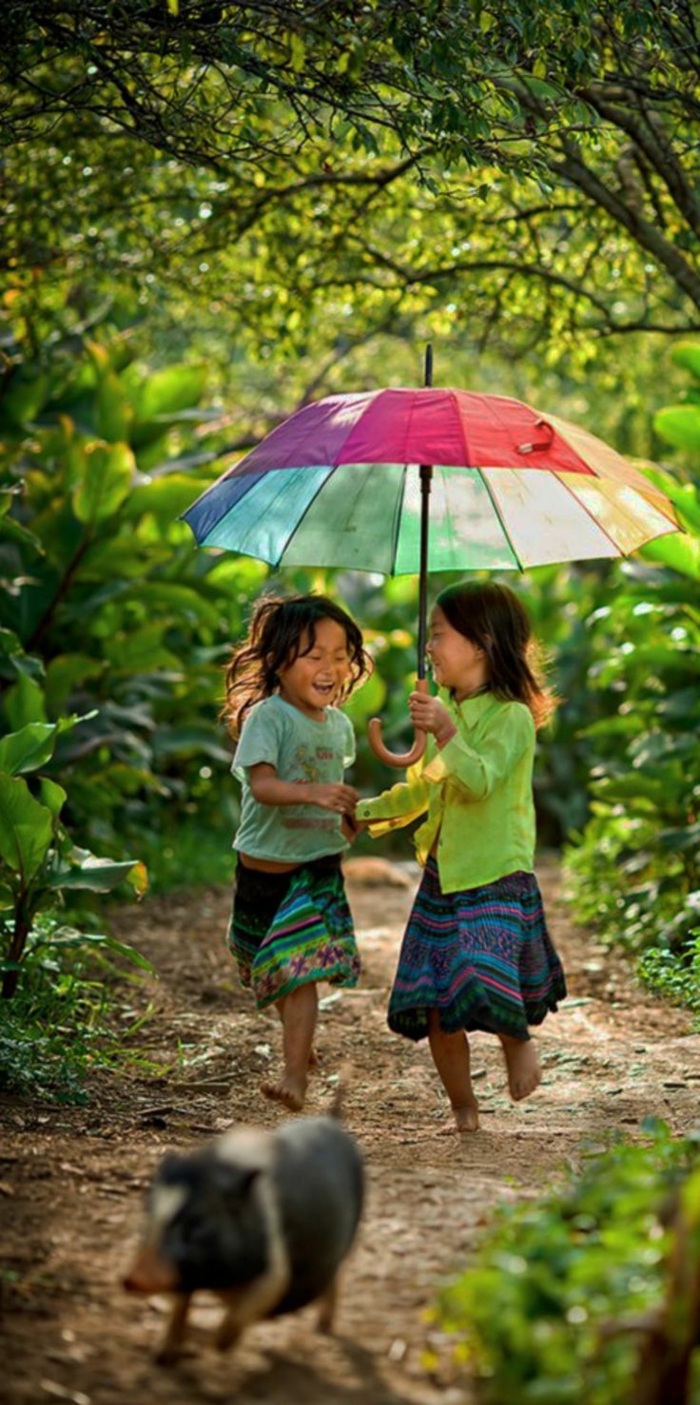 zwei-kleine-Mädchen-buntes-Modell-regenschirm-kinder