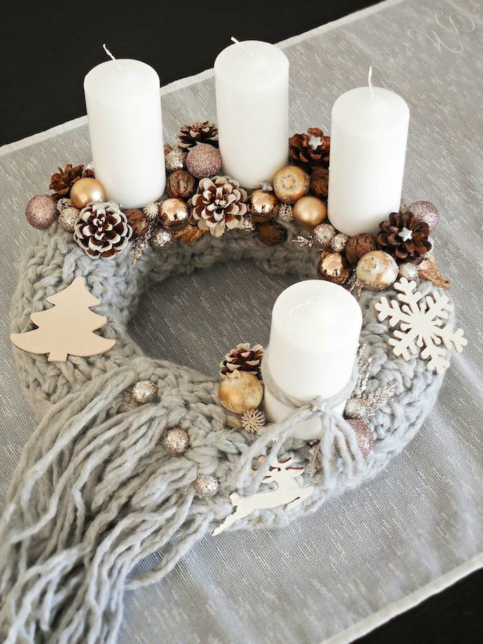 Adventskranz selber basteln, Basis mit Schal umwickeln, mit Weihnachtsfiguren aus Holz, Christbaumkugeln und Zapfen verzieren, vier weiße Kerzen