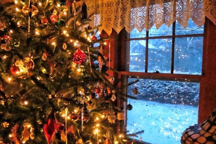 beleuchtete-weihnachtsdeko-am-fenster-großartiger-tannenbaum