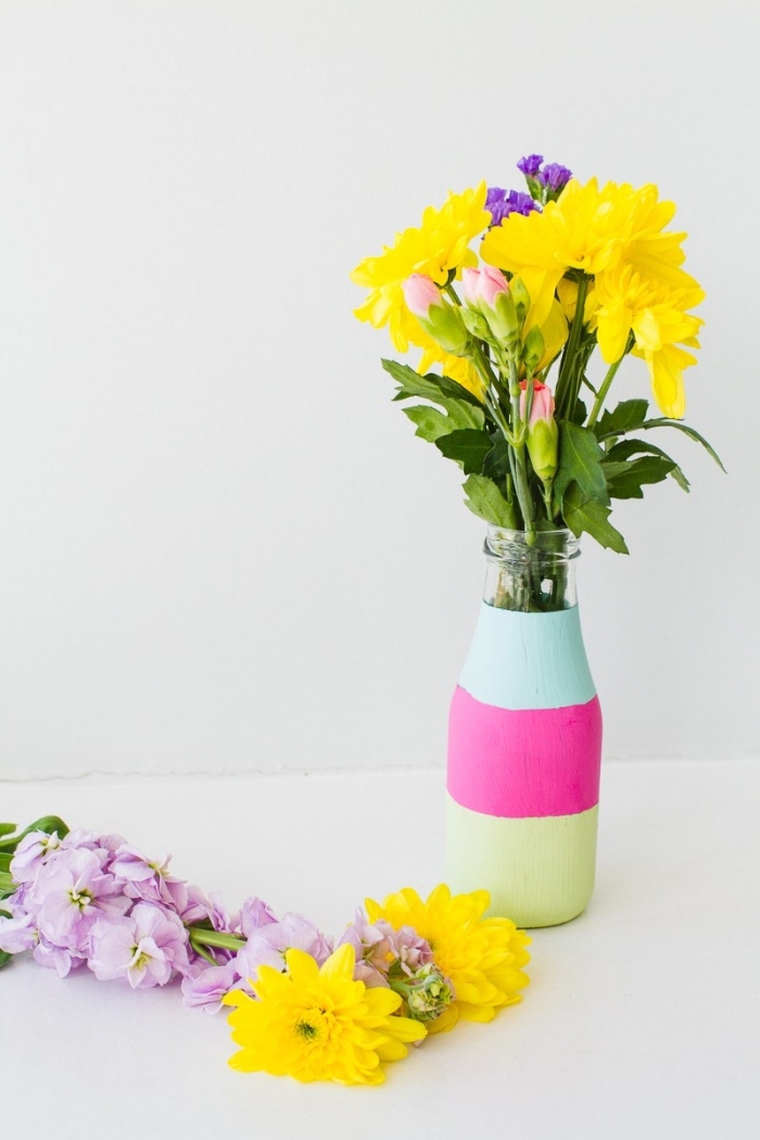gelbe und lila blumen, glasflasche dekoriert mit rosa, grüner und blauer farbe, deko tisch selber machen