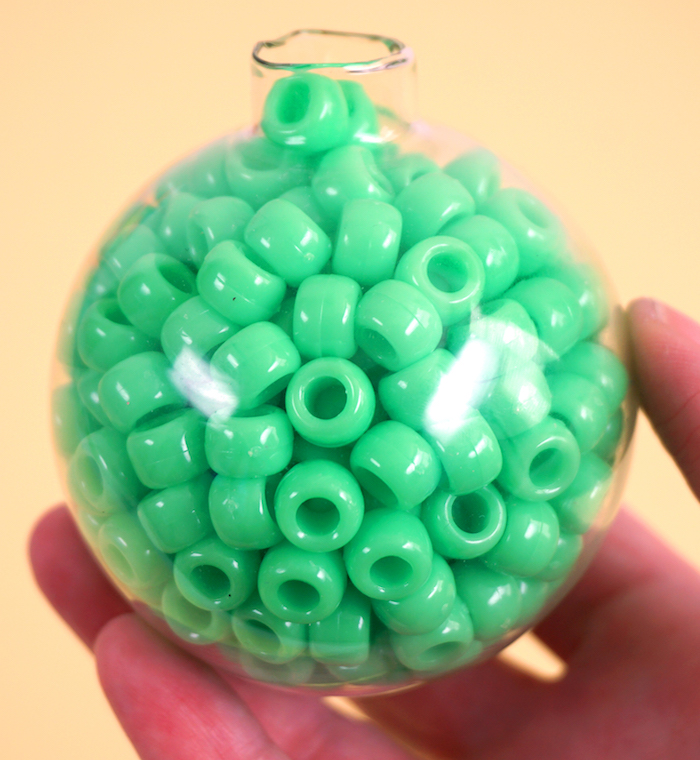 Durchsichtige Christbaumkugel mit grünen Perlen aus Kunststoff füllen, DIY Weihnachtsschmuck 