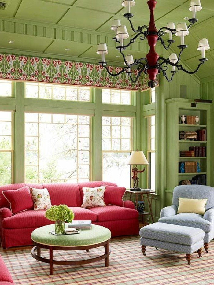 gemütliches-Wohnzimmer-Interieur-grüne-Wände-Zimmerdecke-blauer-Sessel-rote-Couch-farbige-Akzente