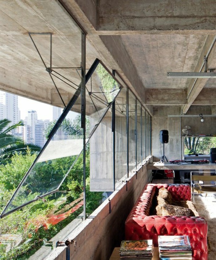 moderne-Wohnung-aus-Beton-und-Glas-rotes-Ledersofa-mit-Knöpfen