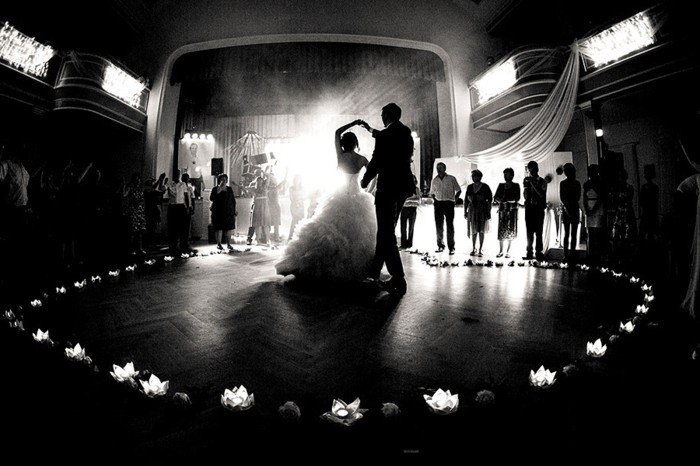romantisches-Hochzeitsbild-der-erste-Tanz-Brautleute-umgeben-von-den-Gästen-Blumen-Kerzen