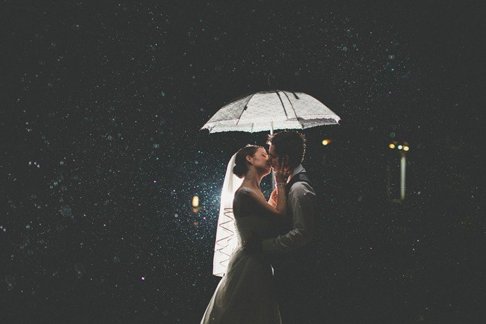 romantisches-Hochzeitsfoto-Brautpaar-Kuss-im-Regen