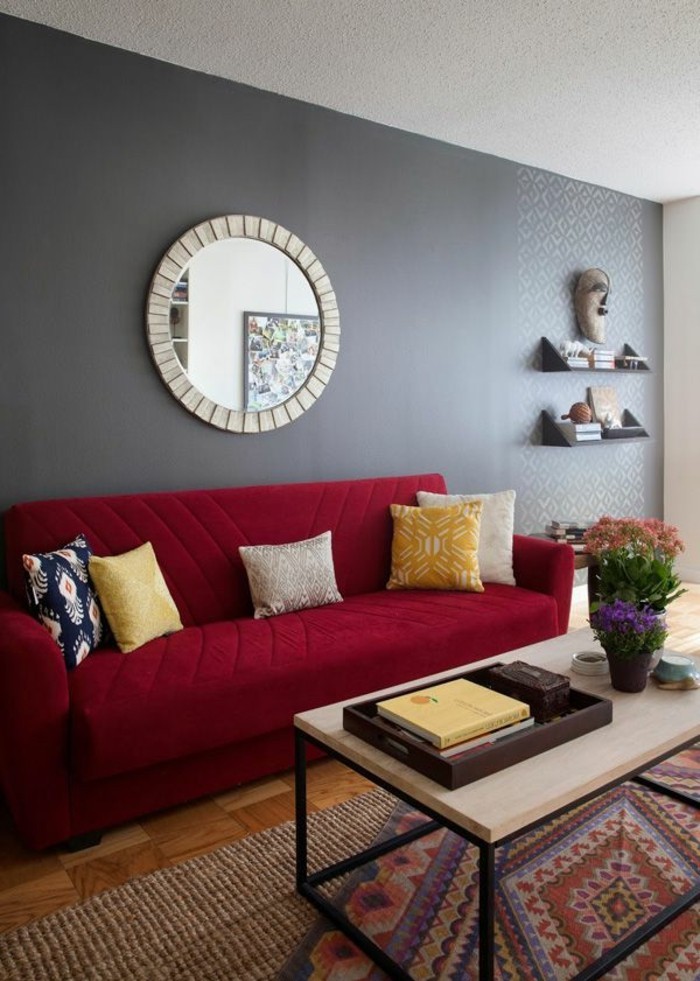 rotes-Sofa-Kissen-mit-modernem-Muster-graue-Wand-runder-Spiegel-vintage-Teppich