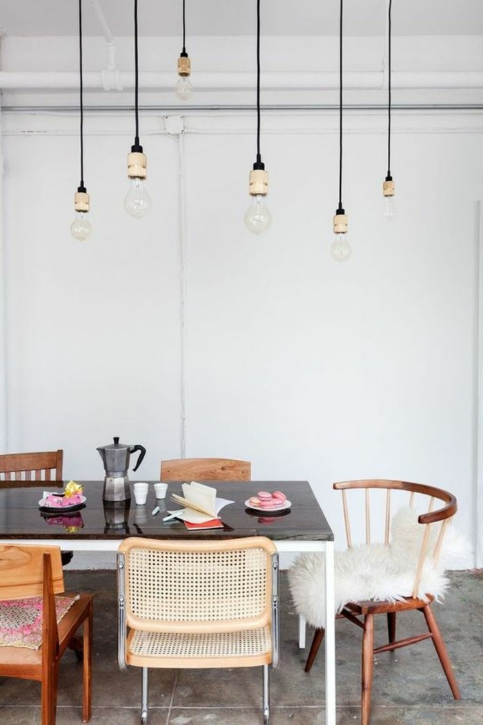 anspruchsloses-Interieur-hängende-Glühbirnen-verschiedenartige-vintage-Stühle