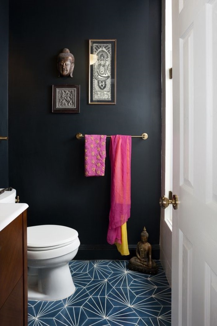 eklektisches-Badezimmer-Interieur-schwarze-Wände-Buddha-Figuren-als-Dekoration-Tücher-in-grellen-Farben-blaue-geometrische-Bodenfliesen-Badezimmer-Fliesen-Modell