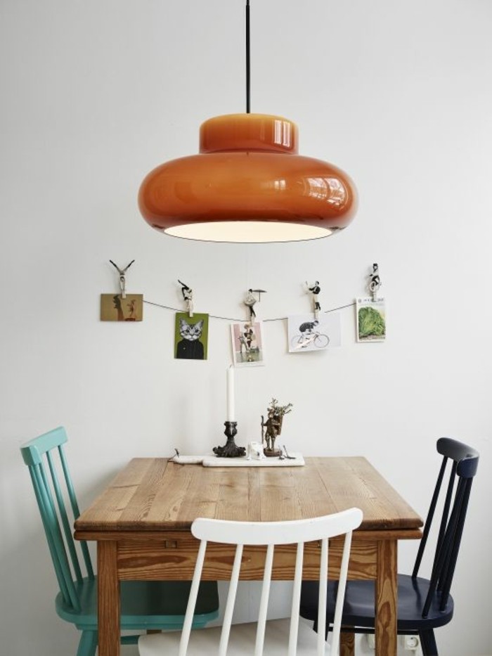 hölzerner-Tisch-bunte-Stühle-Leuchte-in-vintage-Stil