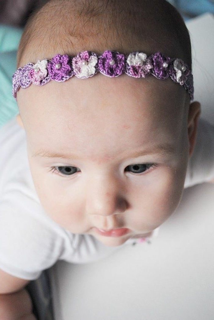 süßes-Baby-mit-lila-Haarschmuck-Blumen