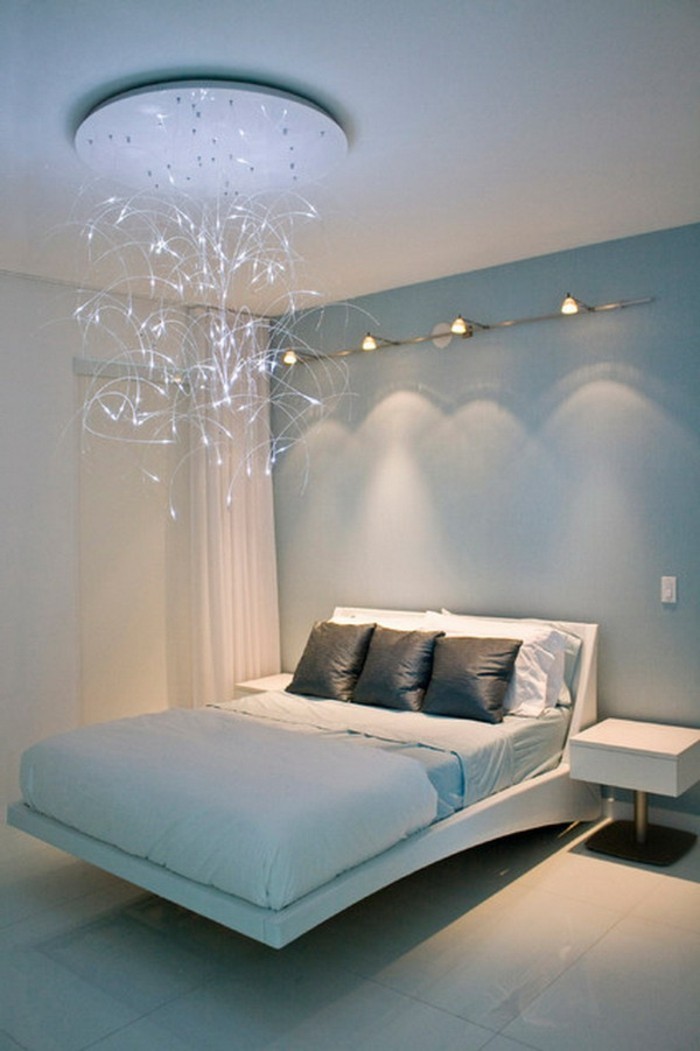 unikaler-kronleuchter-im-attraktiv-gestalteten-schlafzimmer-mit-weißem-bett