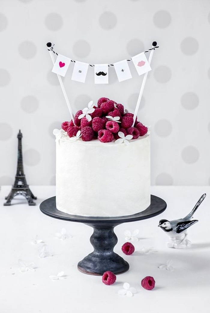 elegante-weiße-Geburtstagstorte-dekoriert-mit-Himbeeren