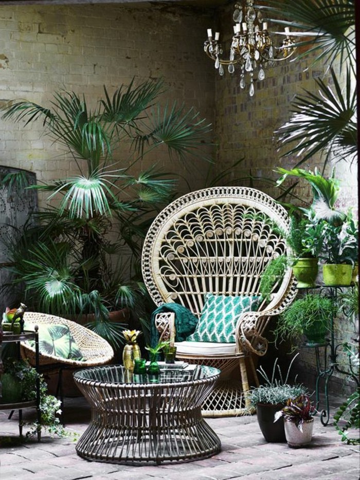 exotische-Atmosphäre-schaffen-Barock-Kronleuchter-Rattanstühle-mit-grünen-Sitzkissen-viele-Pflanzen