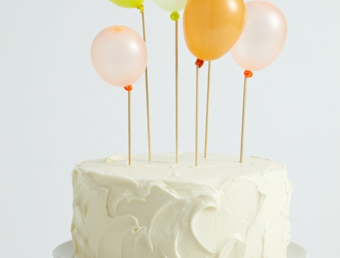 torte mit vanille glasur dekoration bunte luftballons geburtstagskuchen erwachsene minimalistische deko torte