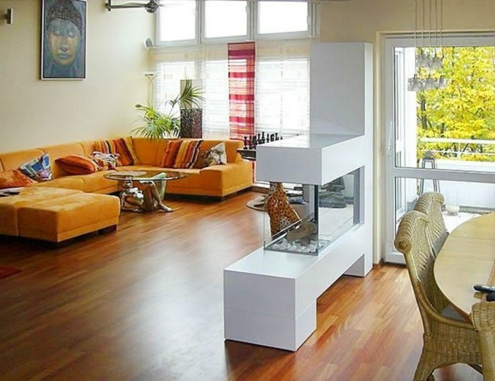 gemütliches-wohnzimmer-gestalten-bioethanol-kaminofen-orange-sofa-wandbild-kopf-couchtisch-frauenfigur
