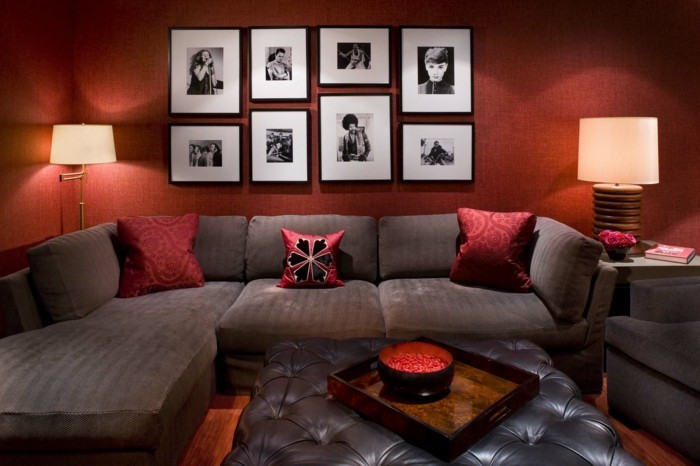 gemütliches-wohnzimmer-gestalten-accessoires-poster-rote-wand-kissen-dunkles-sofa-lampen