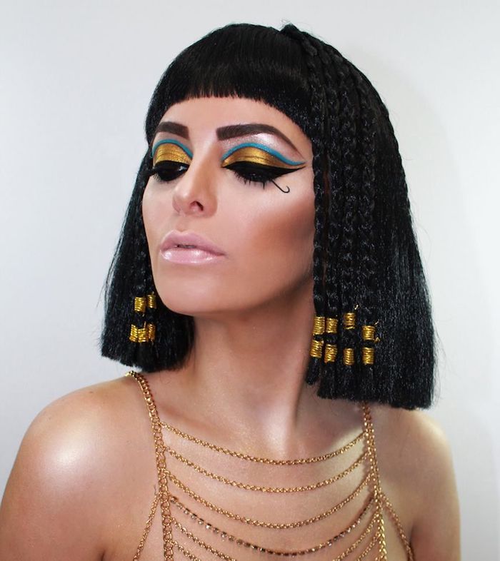 Cleopatra schminken, Goldener und blauer Lidschatten, rosa Lipgloss, Bob Haarschnitt mit Zöpfen und Pony 