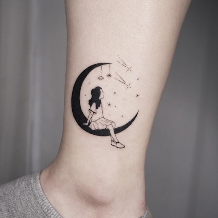 Schwarzes Tattoo am Knöchel, Mädchen sitzend auf dem Mond, kleine Planeten und Sterne, Mädchen mit Shirt und Rock 
