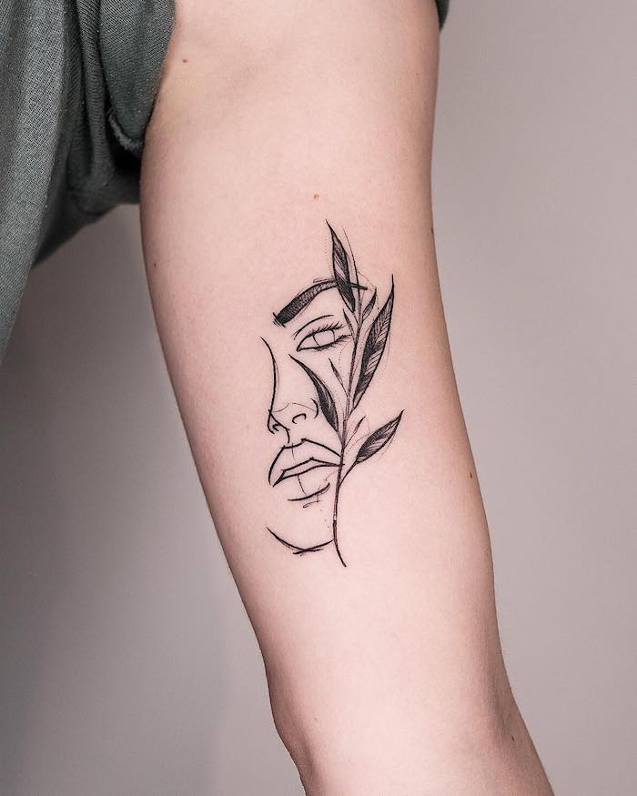 Schönes Tattoo am Oberarm, Frauengesicht und kleine Pflanze, schwarzes Arm Tattoo 