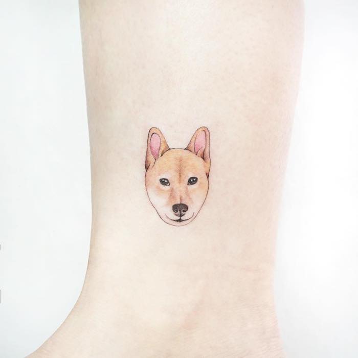 Kleines farbiges Tattoo an der Wade, süßer Hund, sich das Haustier tätowieren lassen 