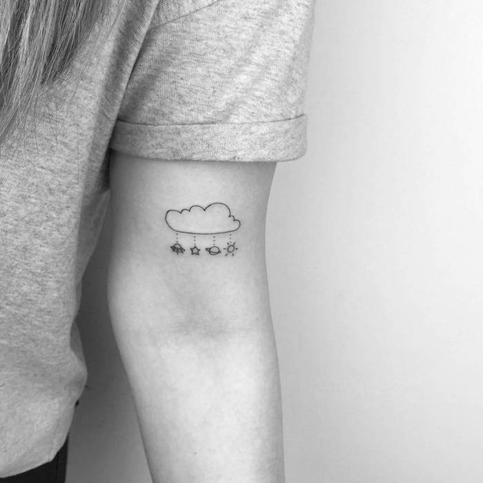 Kleines schönes Tattoo am Oberarm, Wolke und kleine Planeten und Sterne, Tattoo Motive für Frauen 