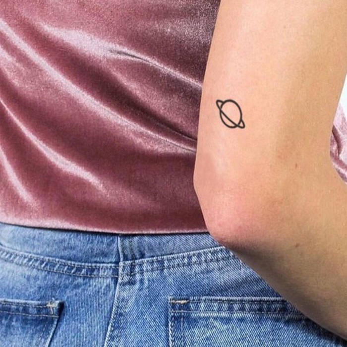 Mini Tattoo am Oberarm, Saturn Tattoo klein, Tattoos mit Bedeutung, kleine Tattoos für Frauen 