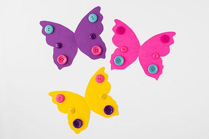 Schmetterlinge basteln mit Kindern, bunte Flügel aus Karton schneiden, mit Knöpfen verzieren