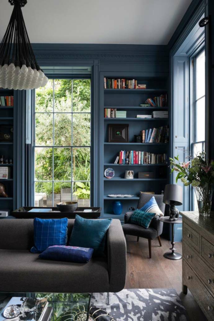 blaues Zimmer, Stellage mit Bücher, modernes Sofa, Kronleuchter mit sichtbaren Glühbirnen, Wohnzimmereinrichtungen