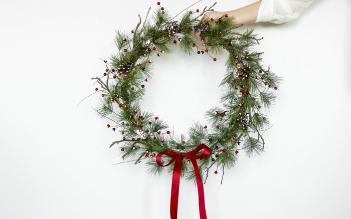 bastelideen weihnachten kreative deko machen hand hält grünen kranz weihnachtskranz selber basteln ideen anleitung