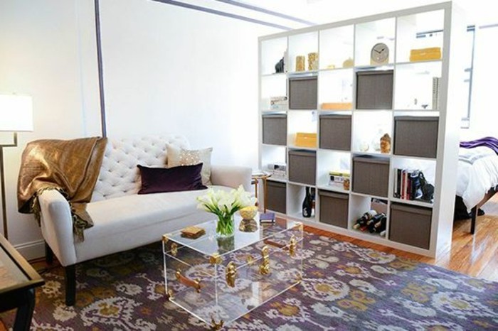 einrichtung-mit-regal-raumteiler-wohnzimmer-schlafzimmer-trennwand-regal-weiße-couch-musterteppich-transparenter-tisch