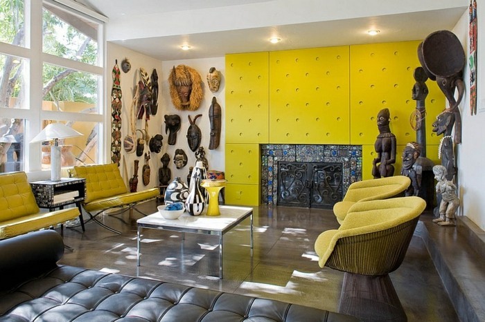 farbige-waende-farbgestaltung-waende-gelbe-wand-feuerstelle-ledercouch-lederstuhl-gelb-polsterstuhl-gelb-holzboden-stufen-wohnzimmer-afrikanische-wanddeko-dekorative-vasen