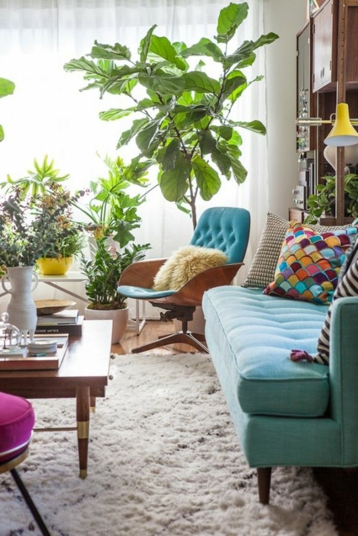 frische-wohnzimmer-farbgestaltung-hellblaue-couch-weisser-teppich-bunte-kissen-blauer-polsterstuhl-holztisch-pflanzenecke-holzbodenzyklamfarbiger-hocker