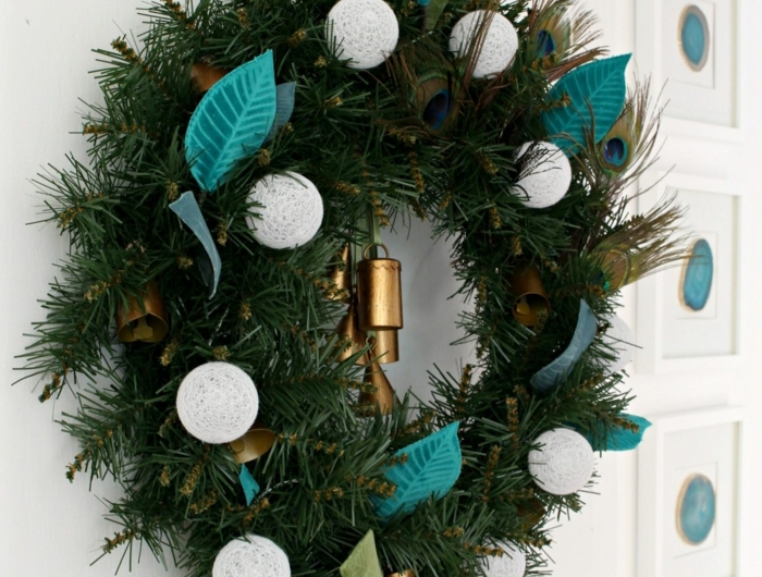 grünen weihnachtskranz selber basteln dekoriert mit weißen weihnachtskugeln blaue federn kranz aufgehängt an tüt