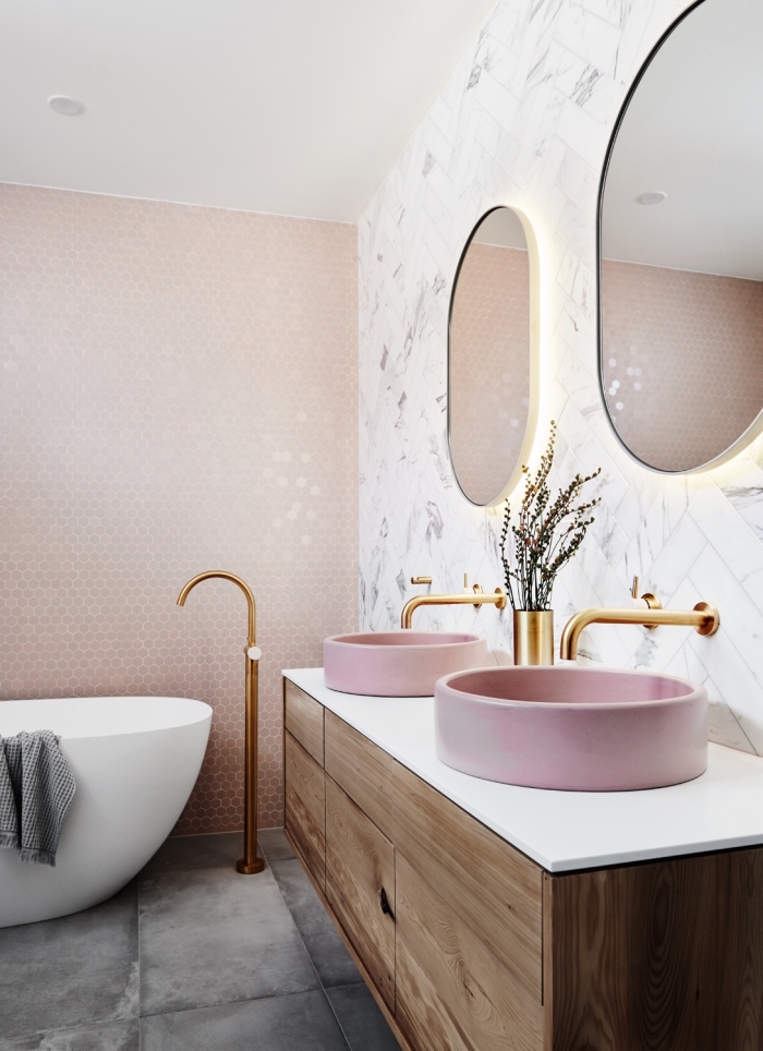 moderne bäder, badgestaltung in weiß und rosegold, rosa waschbecken mit unterschrank aus golt, ovale spiegel mit beleuchtung